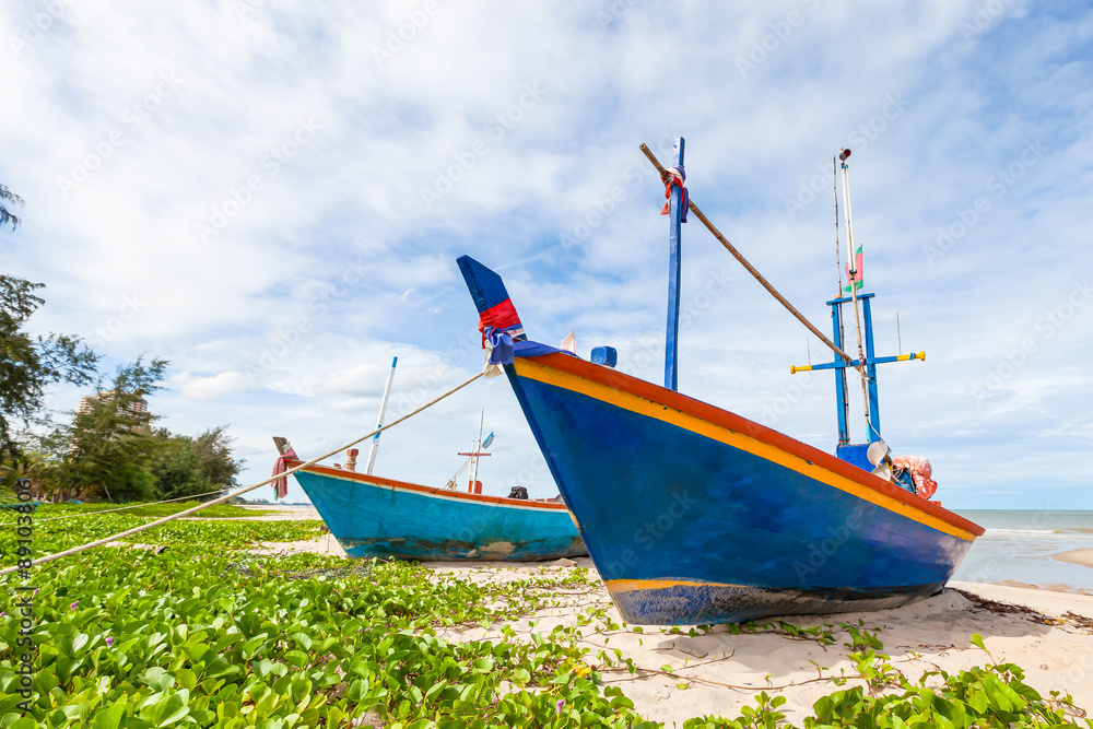 Fishing boat on sand beach and blue sky Fishing boat on sand beach and blue sky