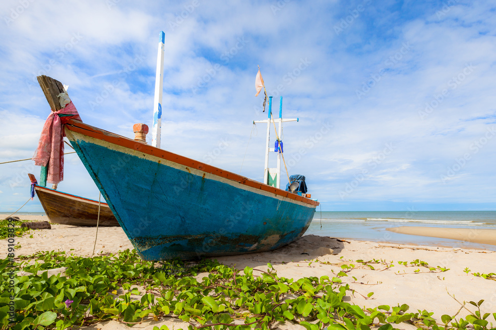 Fototapeta premium Fishing boat on sand beach and blue sky