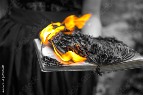 Obraz na płótnie Abstract background - the burning book in women's hands w salonie