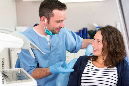 Young attractive dentist explaning his work to a patient