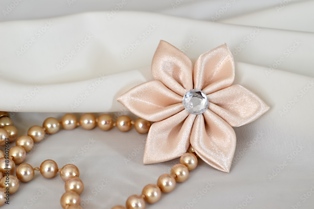 Handmade kanzashi flower and pearls on white background Handmade kanzashi flower and pearls on white background