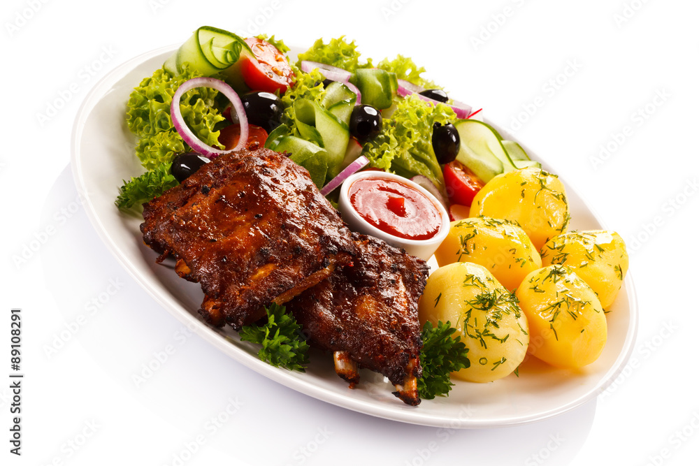 Grilled ribs, French fries and vegetables on white background 