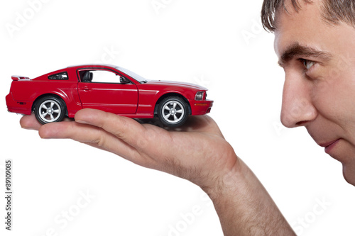 A man holding a red car  on a white background