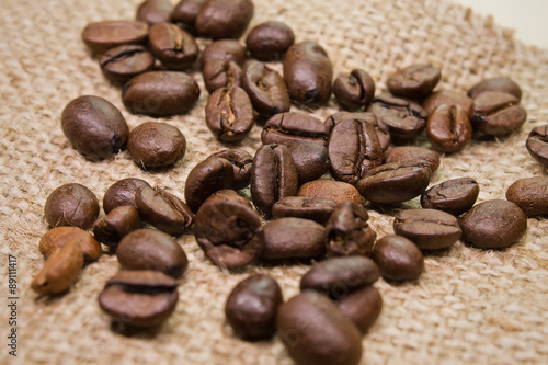 coffee beans scattered on sackcloth closeup