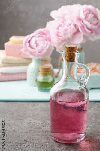 Glass bottle of liquid soap and peonies