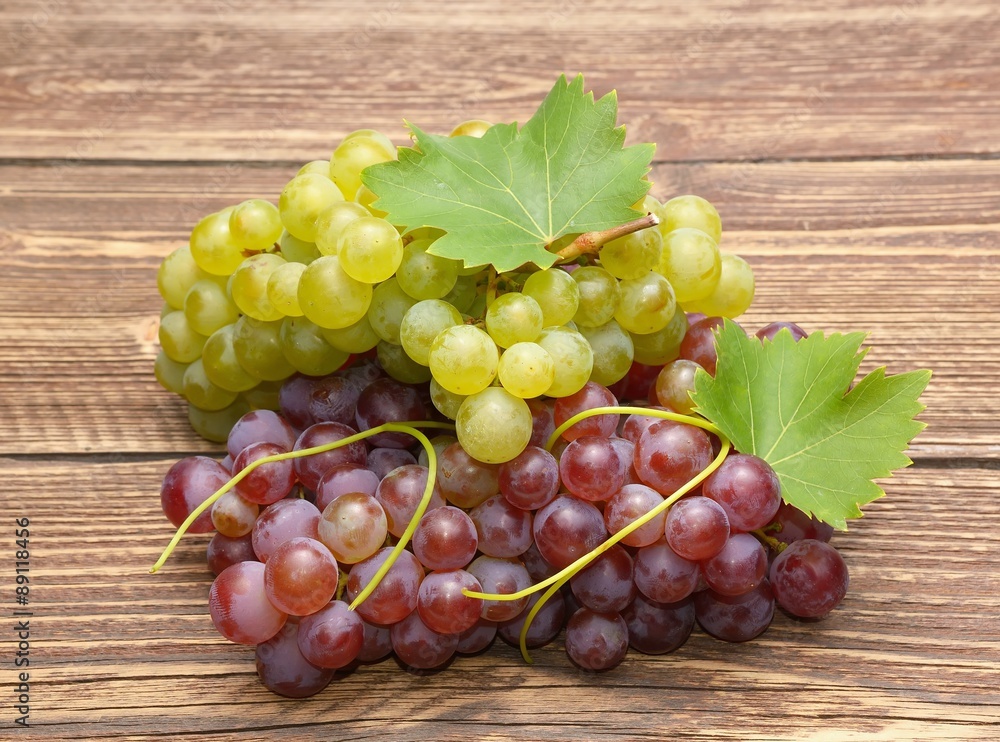 Grapes with leaves on a wooden table Grapes with leaves on a wooden table