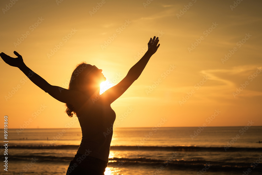 woman open arms under the sunrise at sea