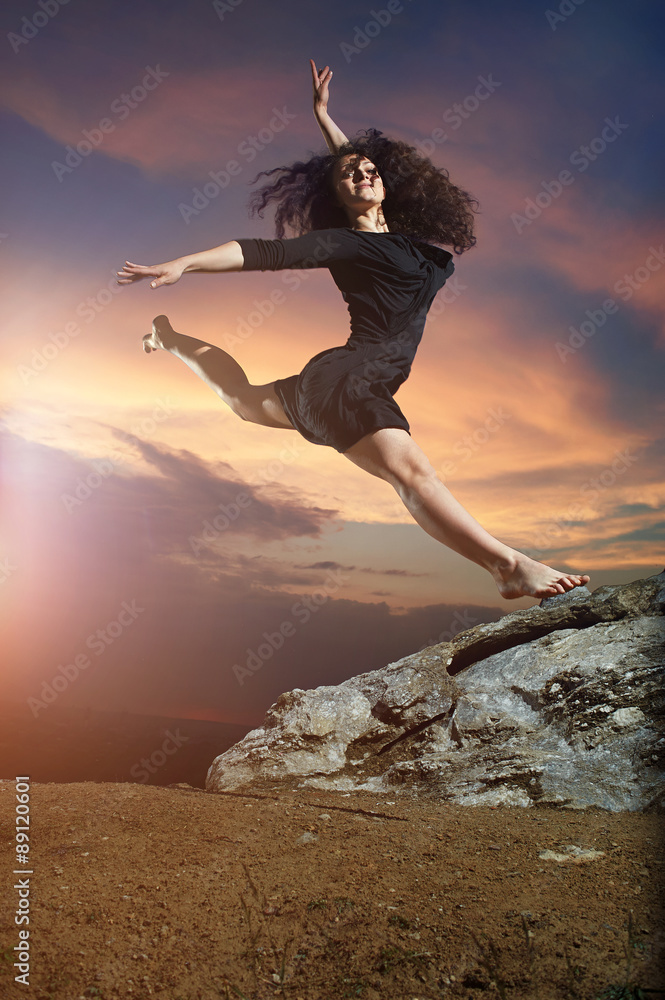 beautiful, flexible, young, curly dancing girl - performs split in the mountains on the wonderful mountain landscape at sunrise.