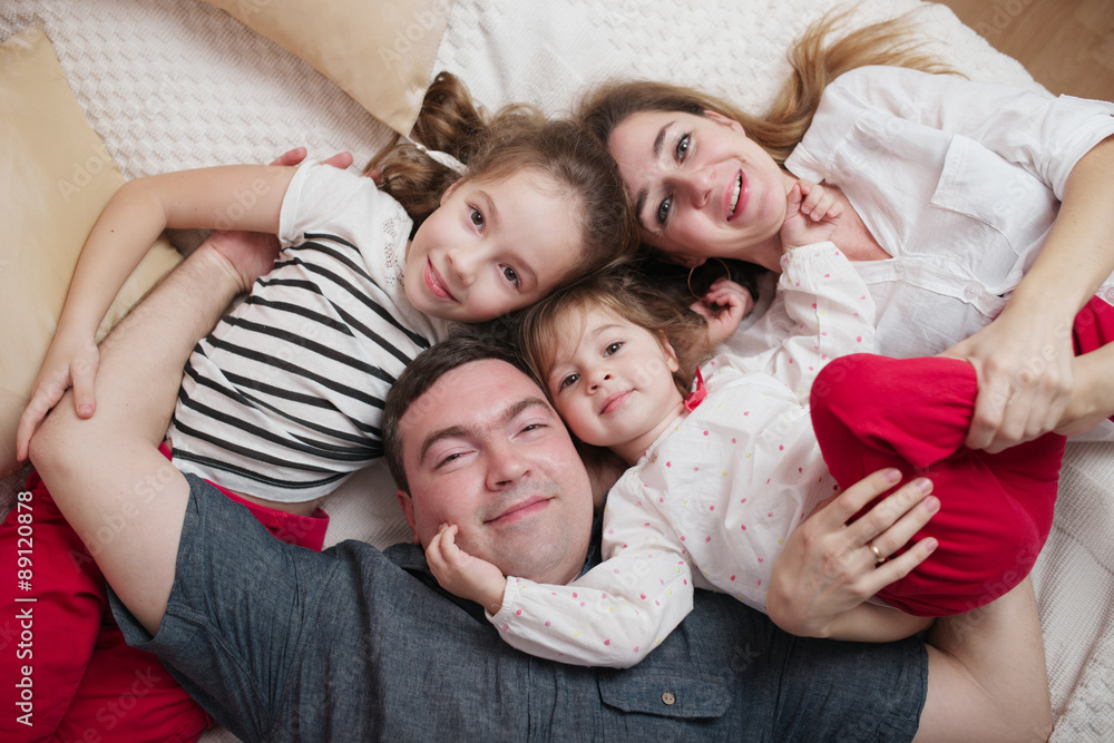 happy young family lying in bed