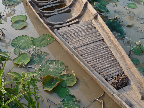 Wooden Handmade Canoe Boat in Asian Lily Pond photo