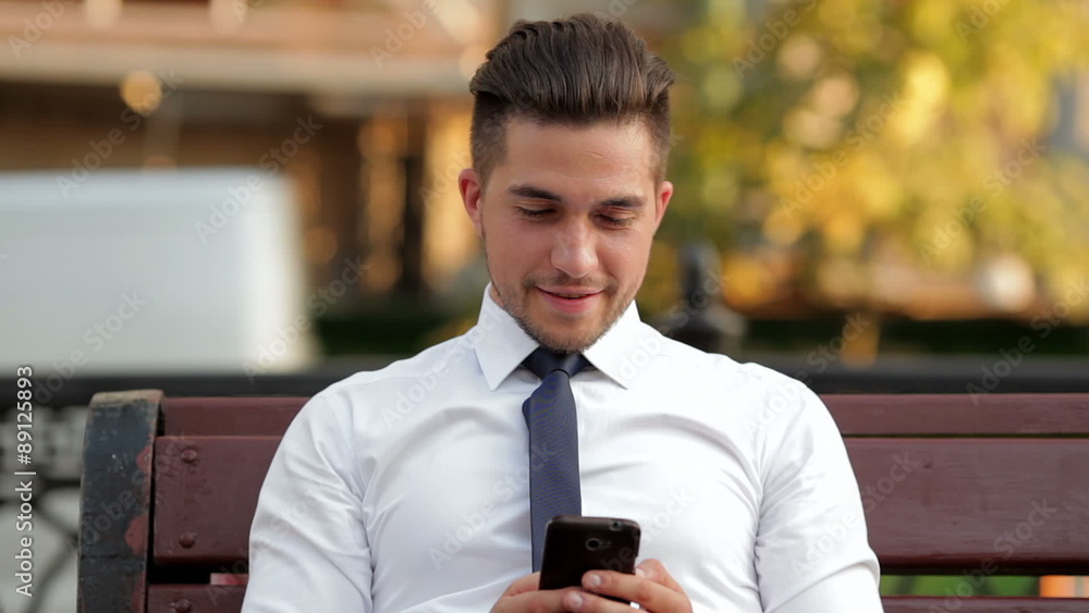 Young businessman sitting on a bench on the street Young businessman sitting on a bench on the street