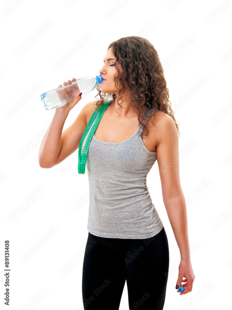 athletic girl with measuring tape on his shoulder drinking water athletic girl with measuring tape on his shoulder drinking water