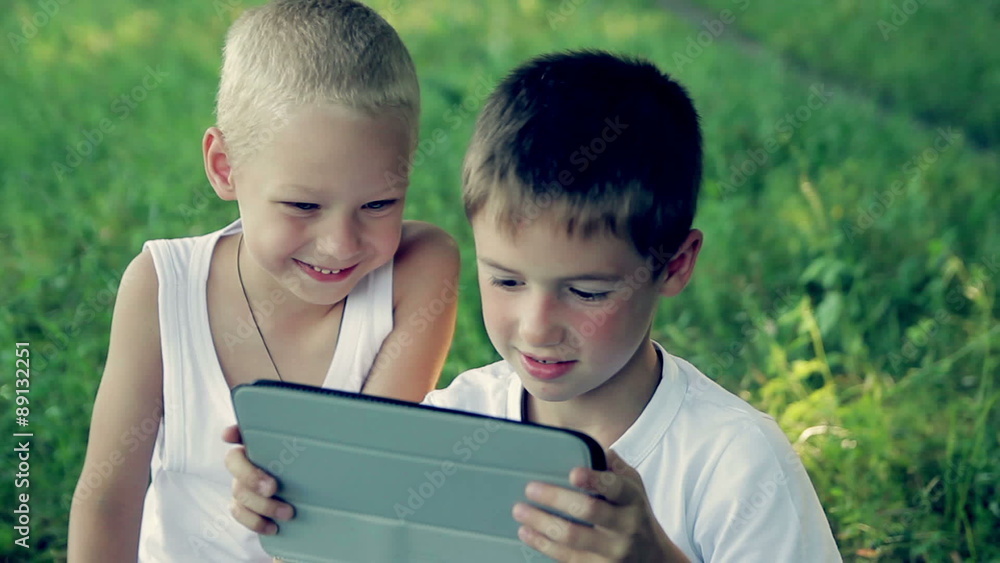 children close up in the park playing on a tablet HD 1080p children close up in the park playing on a tablet HD 1080p