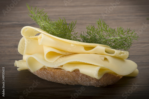 Swiss cheese slices close up on the wood.