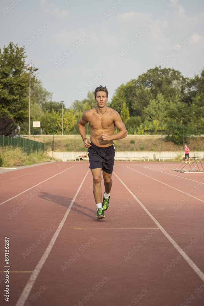 Obraz premium Runner on a track. Frontal full body shot.