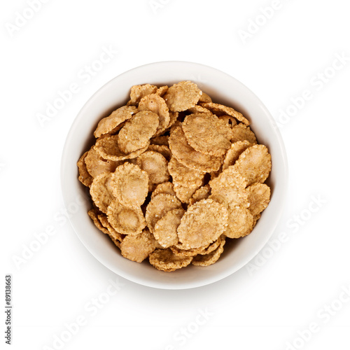 Multigrain flakes in small white plate, isolated. 