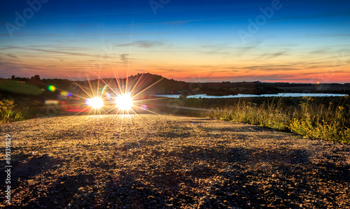 Car with bright light in beautiful mountain landscape sunset sun photo