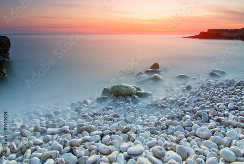 Zachód słońca nad kamienistą plażą