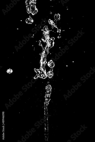 The large jet of water on a black background. Texture.