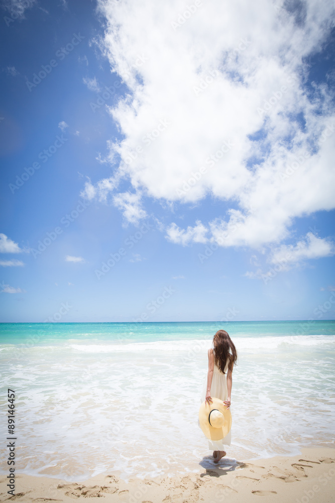 ハワイの海辺でリラックスする女性