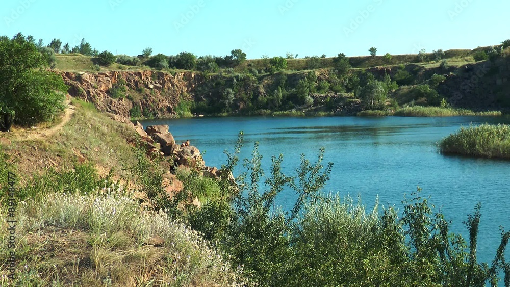 A small lake among the rocks Against the background of the blue sky A small lake among the rocks Against the background of the blue sky