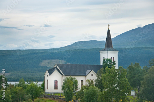 White church by lake near Jarpen in Northern Sweden on an overcast day.