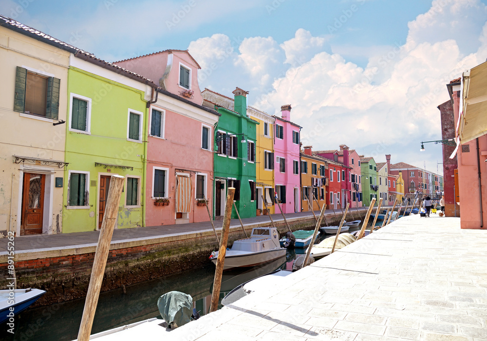 VENICE, ITALY, on APRIL 13, 2015. Burano island, multi-colored houses of locals. Cafe on the bank of the channel. Burano the island - one of attractive tourist objects in the Venetian lagoon VENICE, ITALY, on APRIL 13, 2015. Burano island, multi-colored houses of locals. Cafe on the bank of the channel. Burano the island - one of attractive tourist objects in the Venetian lagoon