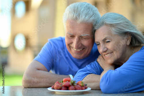 Senior couple in cafe with strawberries