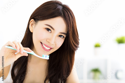Young woman brushing teeth in the morning