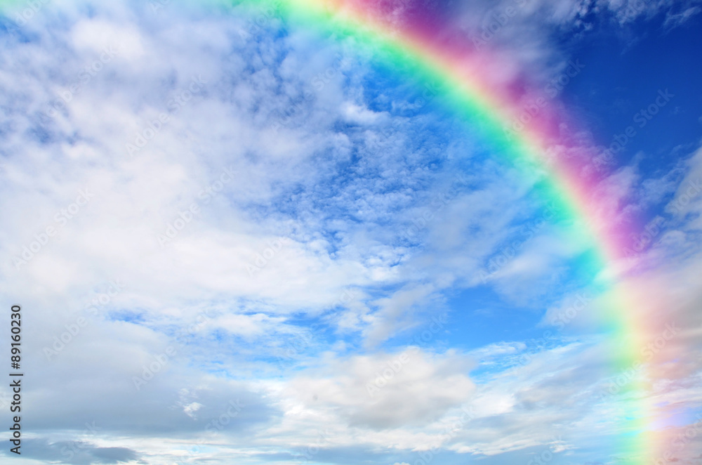 Rainbow and White clouds in blue sky background