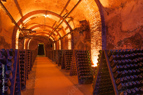 Rows of dusty champagne bottles in Reims cellar, France #89160602