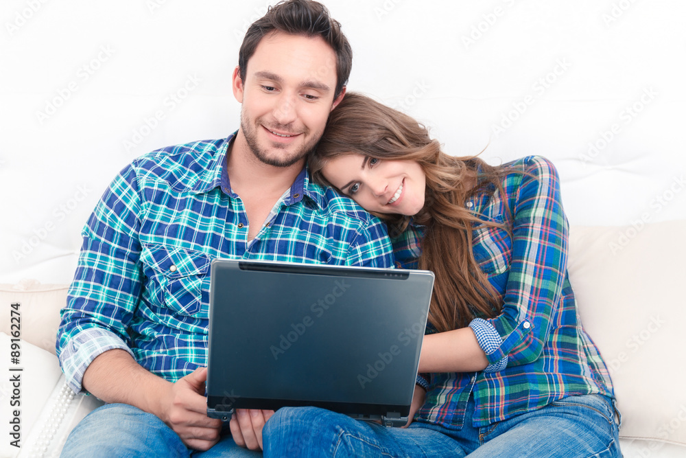 Positive couple holding laptop 