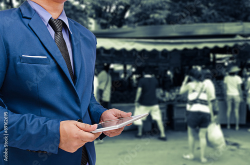 business man holding tablet in hand in blur background