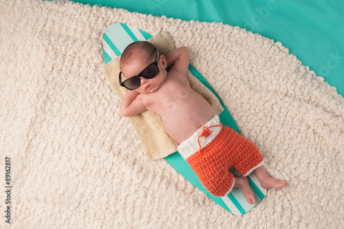 Newborn Baby Boy Sleeping on a Surfboard