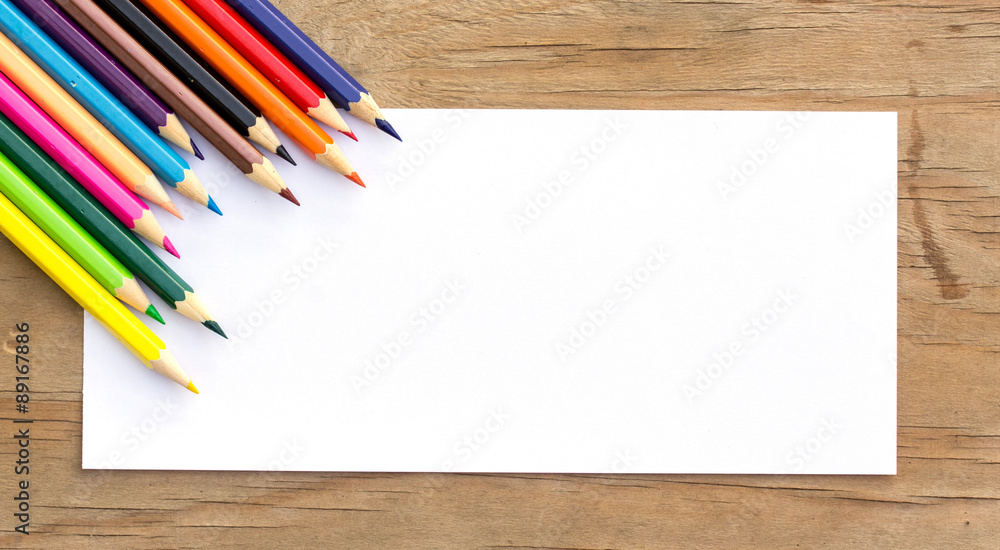 Obraz premium Color Pencils and white paper on wooden background.