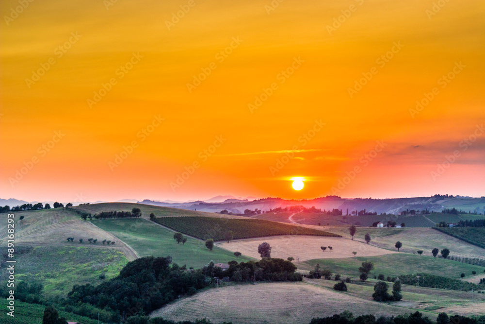 sunset on lush farmland in hilly countryside