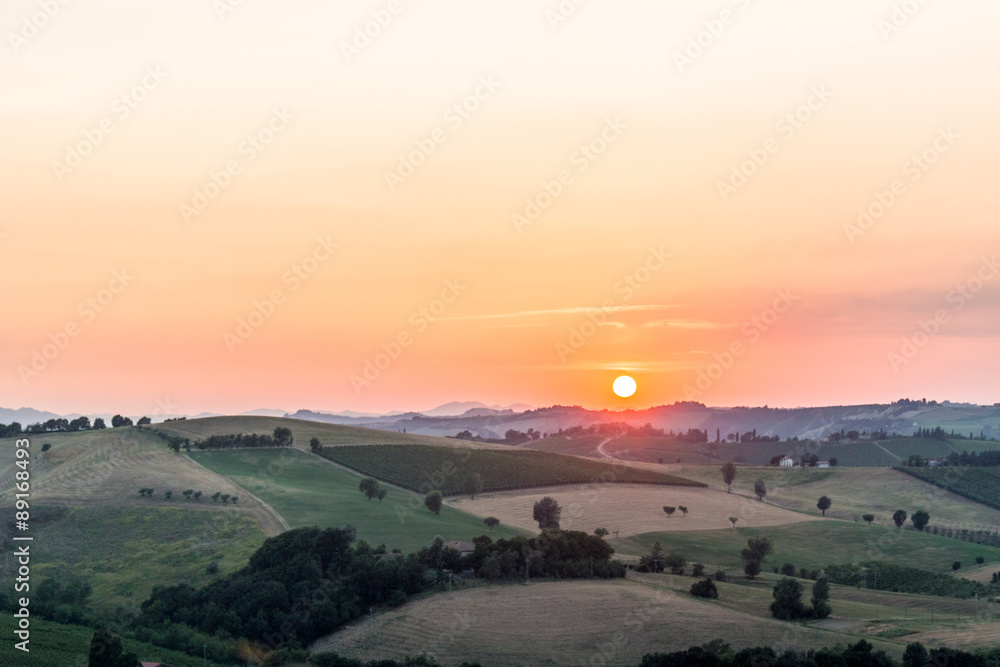 sunset on lush farmland in hilly countryside