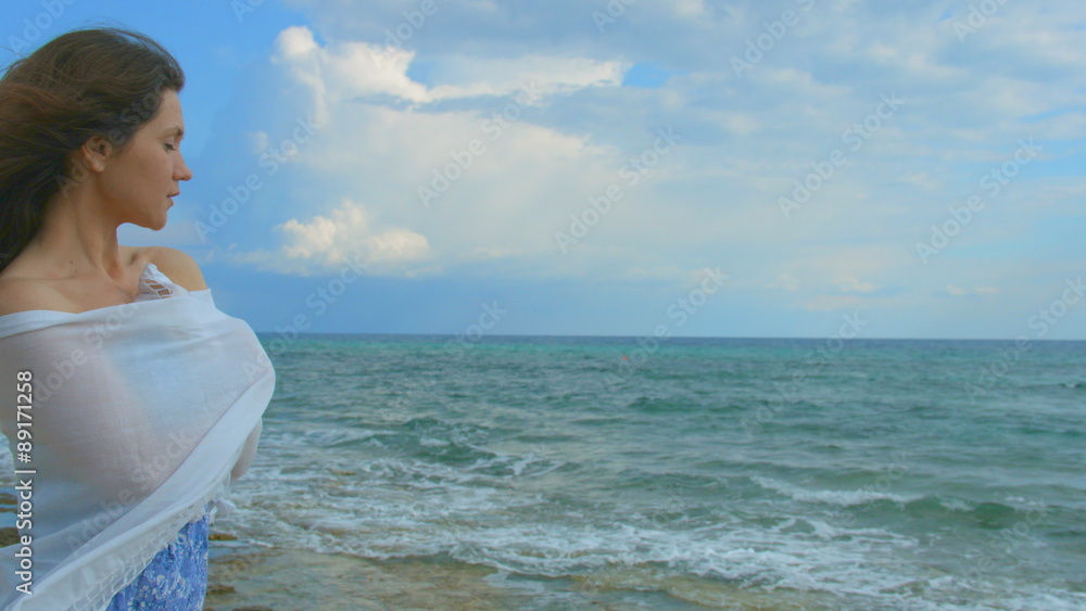 Horizontal panorama of beautiful lonely woman on sea shore, hair waving in wind Horizontal panorama of beautiful lonely woman on sea shore, hair waving in wind
