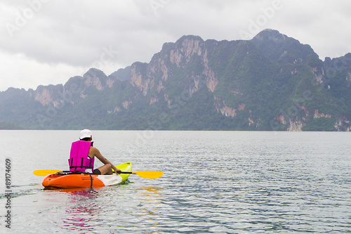 Young man paddling in Chiewlarn dam in Surat Thani, Thailand
