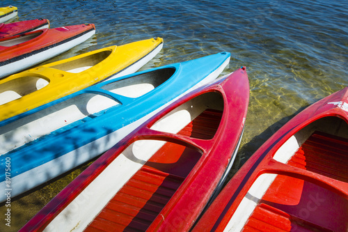 Fototapeta Naklejka Na Ścianę i Meble -  Colorful kayaks moored on lakeshore, Goldopiwo Lake, Mazury, Pol