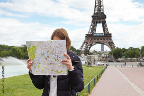 Image of young female tourist with map looking for a way in Pari