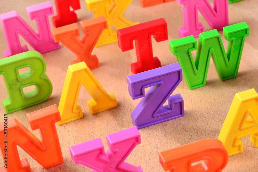 Plastic colorful letters close up on a wooden background Plastic colorful letters close up on a wooden background