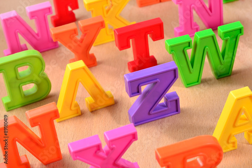 Plastic colorful letters close up on a wooden background
