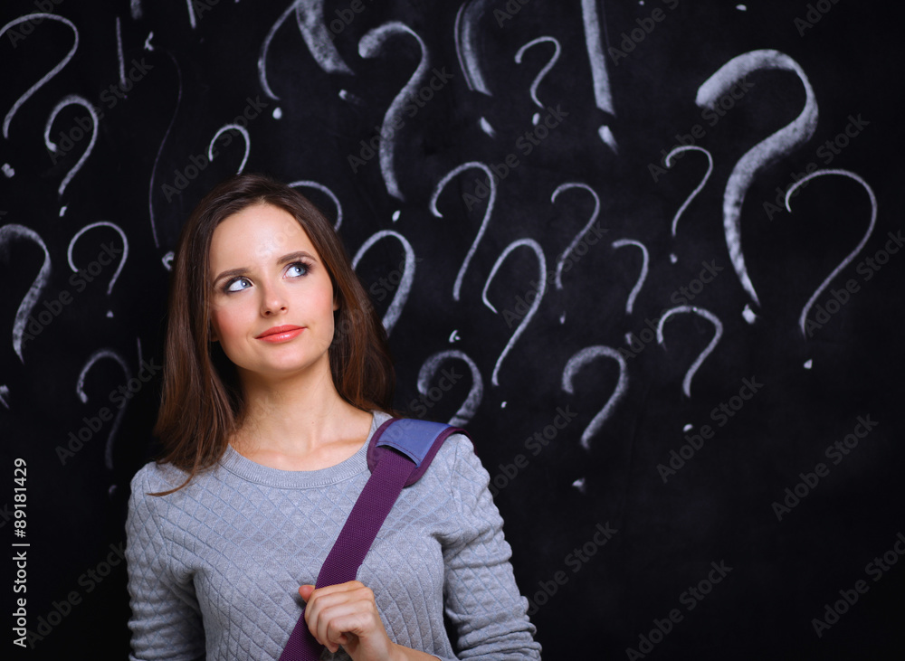 Young girl with question mark on a gray background Young girl with question mark on a gray background