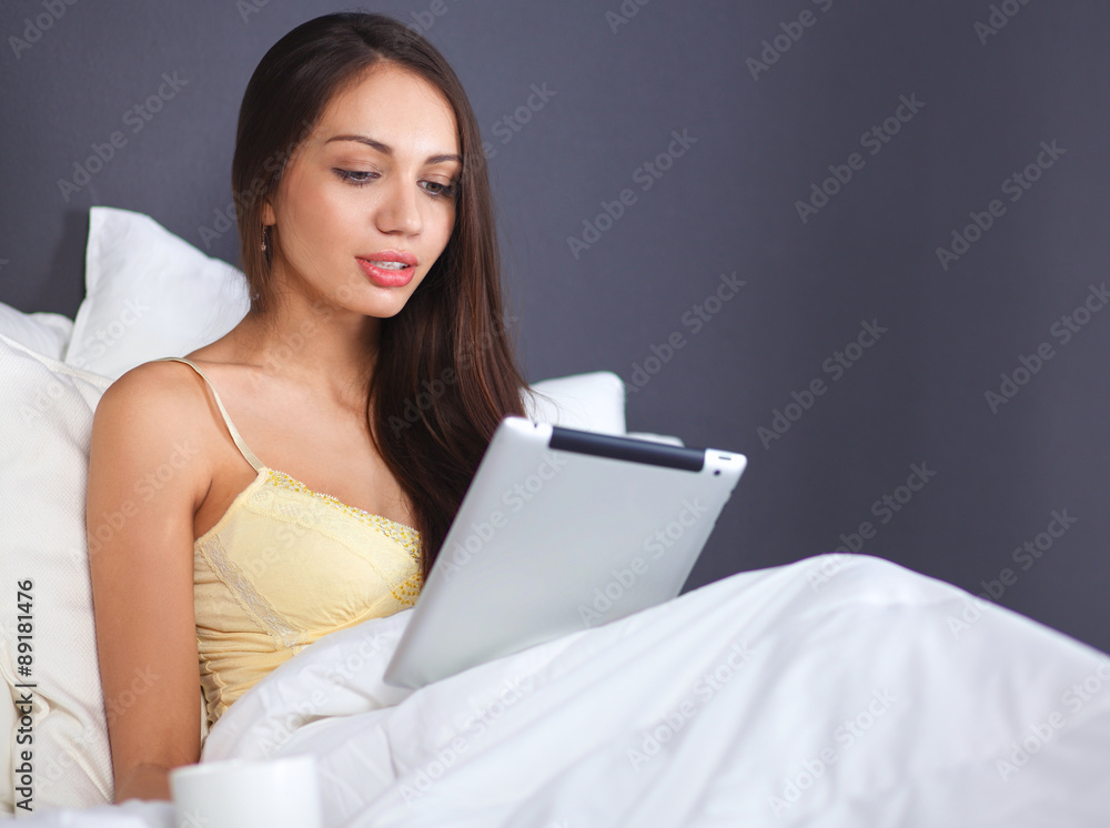 Women use a tablet pc on the bed Women use a tablet pc on the bed