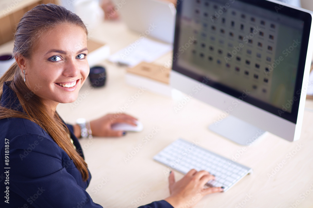 Young woman working in office, sitting at desk, using laptop Young woman working in office, sitting at desk, using laptop