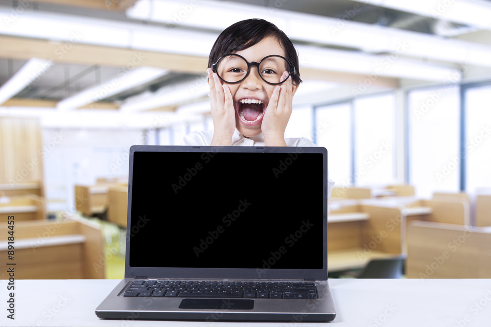 Wunschmotiv: Excited little student with laptop in class #89184453