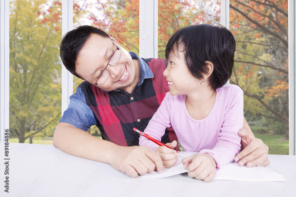 Girl studying with dad near the window Girl studying with dad near the window