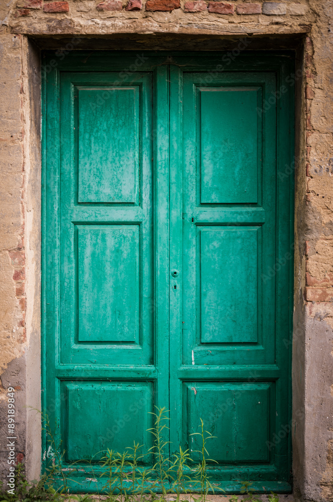 Green door at Toiano, little ghost town in Tuscany, Italy