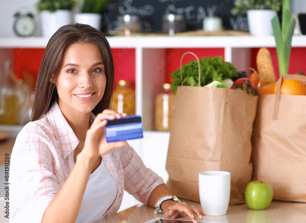 Smiling woman online shopping using tablet and credit card in Smiling woman online shopping using tablet and credit card in